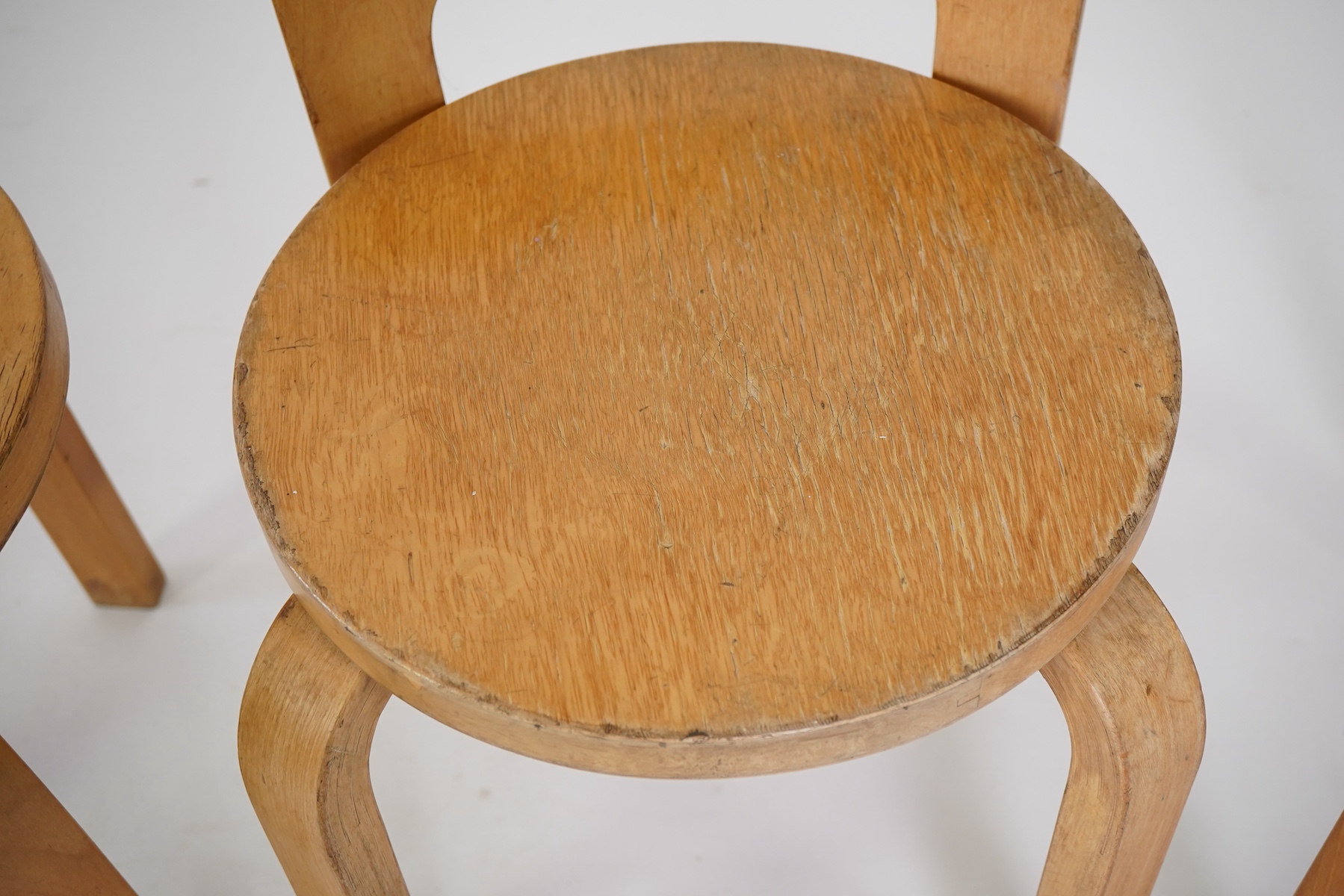 Alvar Aalto (Finnish 1898-1976) for Artek, distributed by Finmar: A pair of 'Model 60' stools and a similar 'K65' stool
